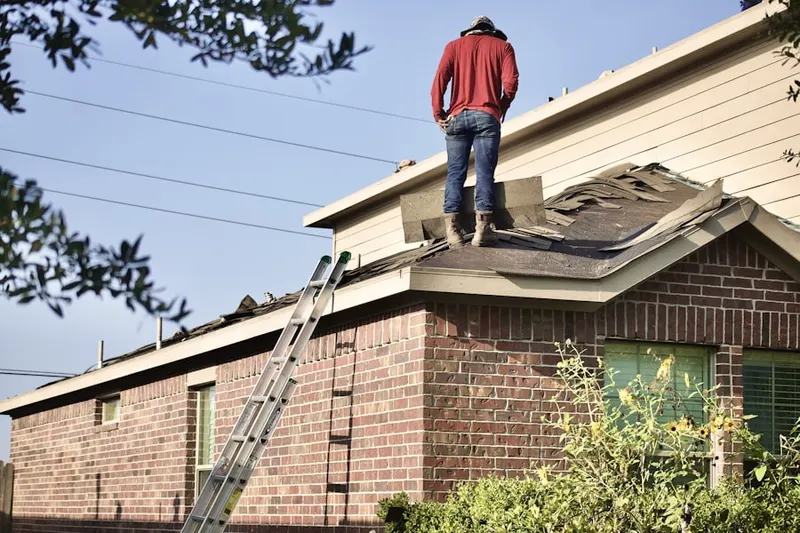 Professional roofer working on a residential roof in Farmington Orchards